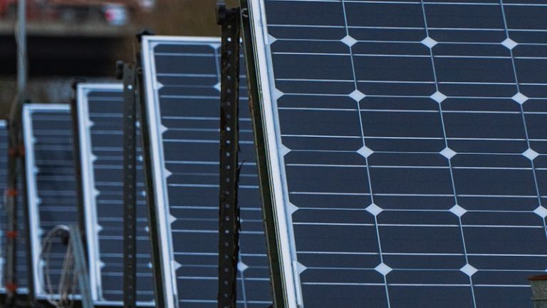 blue solar panels on green metal frame