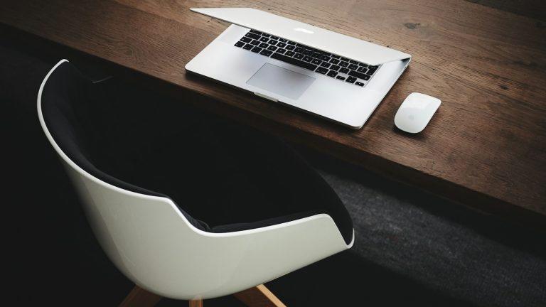 Apple MacBook beside computer mouse on table